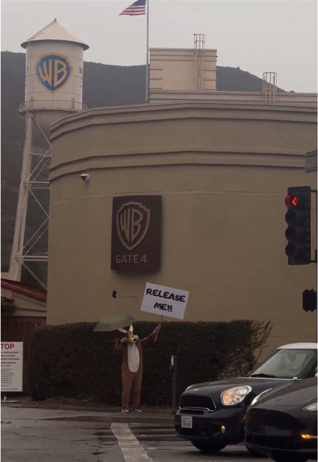 Coyote vs. Acme fan protester dressed as Wile E. Coyote holding a Release Me sign outside Warner Bros. Studios
